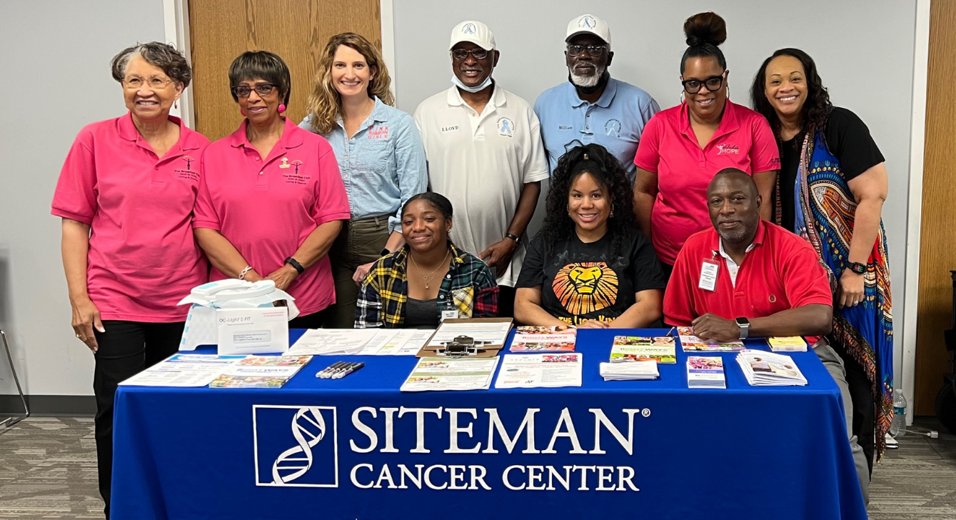 Image of 10 people standing together at a Siteman Cancer Center tabling event and showing community support.